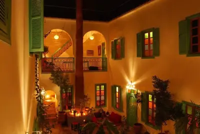 a building with a room with tables and windows at Riad Dar Aida in Marrakech