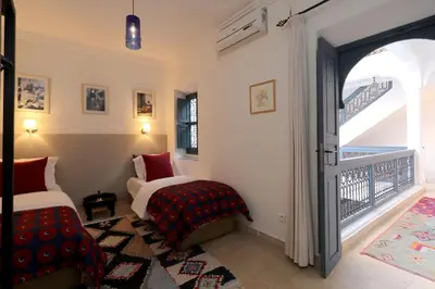 a bedroom with two beds and a balcony at Riad Dar Safi, privatise 6 à 8 pers, bain exterieur in Marrakech