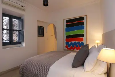 a bedroom with a bed and a surfboard on the wall at Riad Dar Safi, privatise 6 à 8 pers, bain exterieur in Marrakech