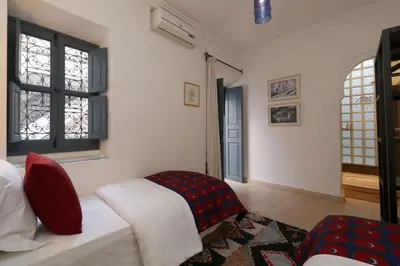 a bedroom with a bed and a red chair at Riad Dar Safi, privatise 6 à 8 pers, bain exterieur in Marrakech