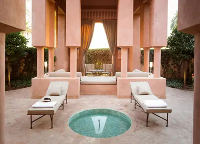 a courtyard with two chairs and a small pool at Amanjena Resort in Marrakech