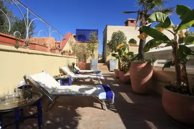 a row of lounge chairs on a patio with plants at Riad Infinity Sea in Marrakech