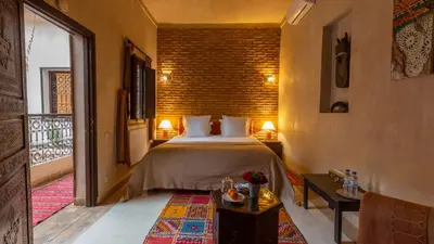 a bedroom with a bed and a brick wall at Les Sources berbères Riad & Spa in Marrakech