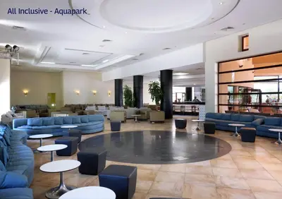a hotel lobby with blue couches and tables at Valeria Madina Club - All Inclusive in Marrakech