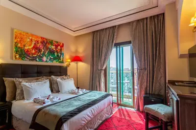 a hotel room with a bed and a large window at Le Caspien Boutique Hotel in Marrakech