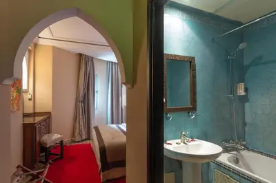 a bathroom with a sink and a tub and a bed at Le Caspien Boutique Hotel in Marrakech