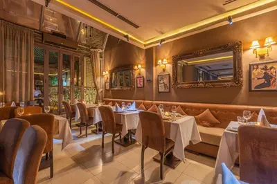 a restaurant with tables and chairs and a mirror at Le Caspien Boutique Hotel in Marrakech