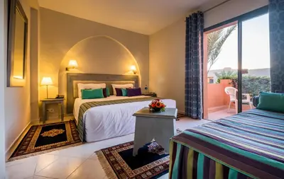 a hotel room with two beds and a balcony at Valeria Dar Atlas All Inclusive in Marrakech