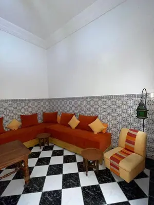 a living room with a couch and a checkered floor at Riad NEJJARINE in Marrakech