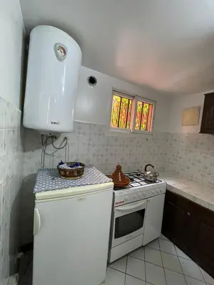 a kitchen with a white stove and a white refrigerator at Riad NEJJARINE in Marrakech