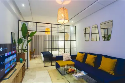 a living room with a blue couch and a television at Stylish Studio(WiFi, Netflix, Pool, AC, Nespresso) in Marrakech