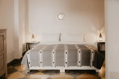 a white bed in a room with two lamps at Riad Alnadine in Marrakech