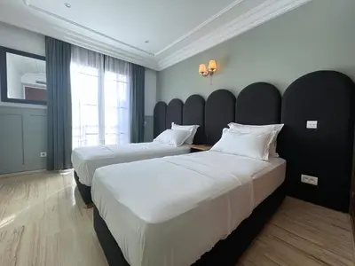 a hotel room with two beds and a large window at Chimera Apartments & Suites in Marrakech