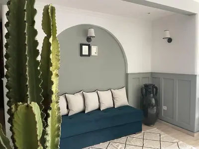 a living room with a blue couch and a cactus at Chimera Apartments & Suites in Marrakech