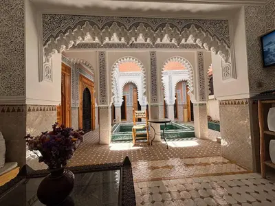 a room with a table and a vase of flowers at Riad Minami in Marrakech