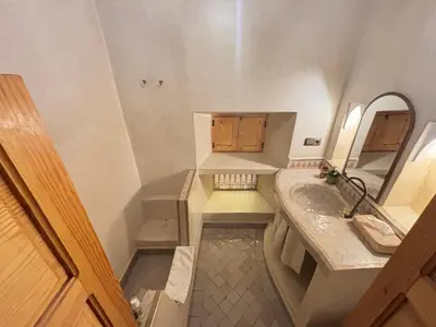 a small bathroom with a sink and a mirror at Riad Minami in Marrakech