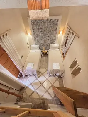 an attic room with two beds and a table at Riad Minami in Marrakech