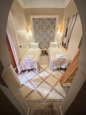 two beds in a room with a staircase at Riad Minami in Marrakech