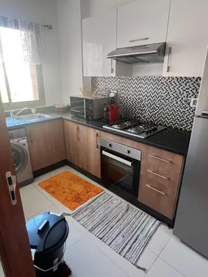 a small kitchen with a stove and a sink at Comme a la maison Prestigia Golf acces piscine in Marrakech