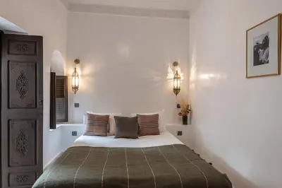 a bedroom with a bed and two lights on the wall at Riad Babouchta & Spa in Marrakech