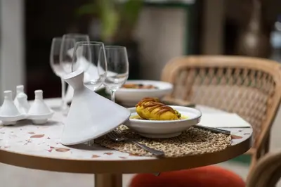 a table with a plate of food and wine glasses at Riad Babouchta & Spa in Marrakech