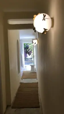 a hallway with a light fixture and a hallway with rugs at MORO Marrakech Boutique Hôtel in Marrakech