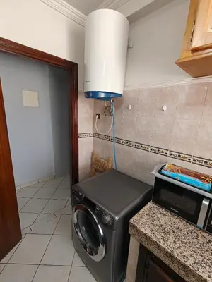 a washing machine in a kitchen with a lamp at Bright Air Conditioned Apartment Near City Center in Marrakech
