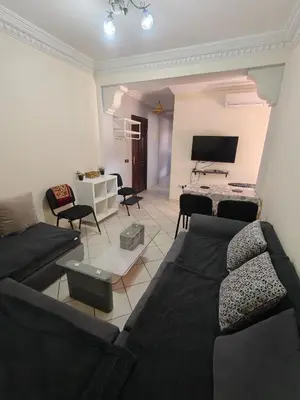 a living room with a couch and a tv at Bright Air Conditioned Apartment Near City Center in Marrakech