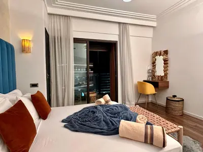 a bedroom with a bed with a blue blanket on it at Zara Apartments Marrakech in Marrakech