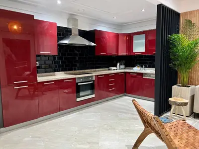 a red kitchen with red cabinets and a sink at Zara Apartments Marrakech in Marrakech