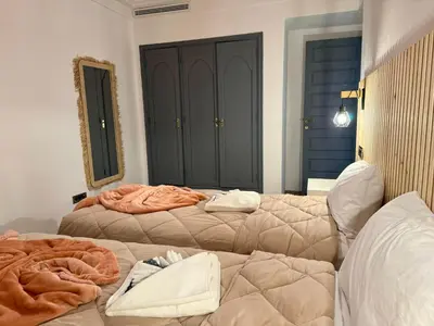 a bedroom with two beds and a mirror at Zara Apartments Marrakech in Marrakech