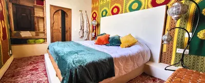 a bedroom with a bed with colorful pillows on it at Riad Ayada in Marrakech