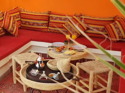 a living room with a table and chairs and a couch at Riad Ayada in Marrakech
