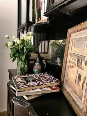 a table with a picture and a vase with flowers at DAR CHIBANIA in Marrakech