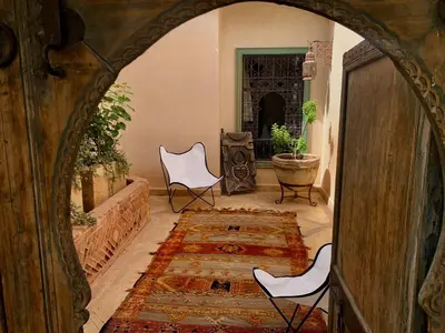 an archway in a room with two chairs and a rug at DAR CHIBANIA in Marrakech