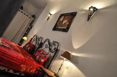 a bedroom with a bed with a red comforter at Riad Mandalay in Marrakech