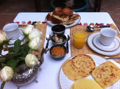 a table with plates of food and a bowl of bread at Riad Mandalay in Marrakech
