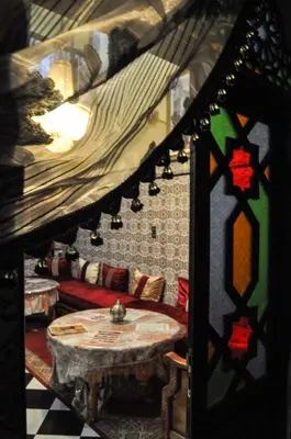 a living room with a table and a couch at Riad Fattouma Kasba in Marrakech