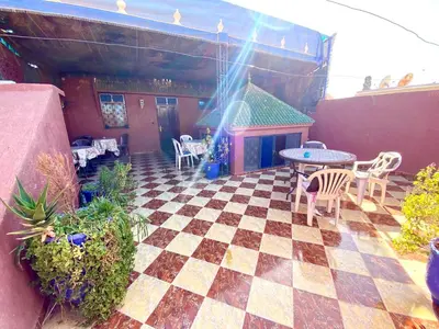 a patio with a table and chairs on a checkered floor at Riad Fattouma Kasba in Marrakech