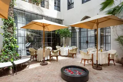 a patio with tables and umbrellas and a fire pit at Palais Khum in Marrakech