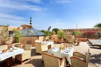 a patio with tables and chairs on a roof at Palais Khum in Marrakech