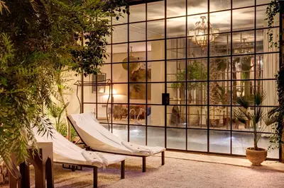 a room with two hammocks in front of a large window at Palais Khum in Marrakech