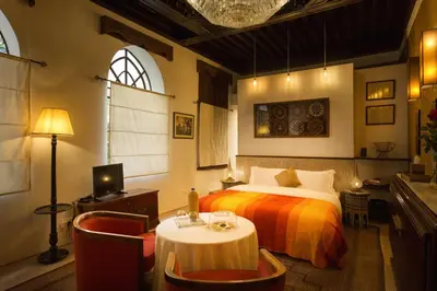 a bedroom with a bed and a table and chairs at Palais Khum in Marrakech
