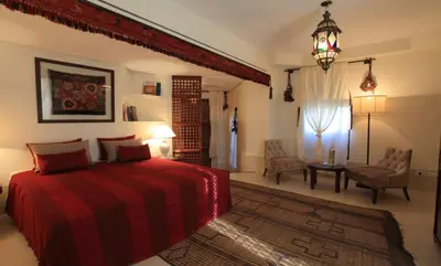 a bedroom with a bed and a table and a chair at Palais Khum in Marrakech