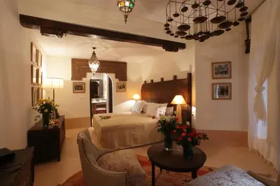 a bedroom with a bed and a couch and a table at Palais Khum in Marrakech