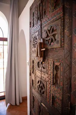 a wooden door in a room with a curtain at Riad Ben Youssef in Marrakech