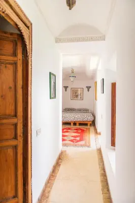 a hallway with a door and a bed in a room at Riad Ben Youssef in Marrakech