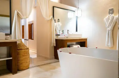 a bathroom with a large white tub and a sink at Riad Houma in Marrakech