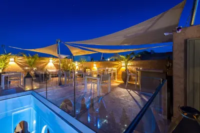 a patio with a swimming pool at night at Riad Houma in Marrakech