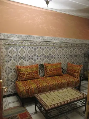 a living room with a couch and a wall at Sindi Sud in Marrakech